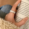 Close-up of minimalist silver chain ring worn on finger against casual knitwear backdrop - Silver - Braided Chain Style (C-430)