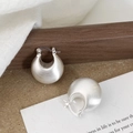 Detailopname van zilveren geborstelde druppeloorringen op een houten standaard - Zilveren U-vormige Waterdruppel Geborstelde Creolen (A-954)
