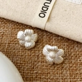 Macro detail of matte silver flower earrings with fine petal texture on rustic fabric - Silver Matte Flower Studs (A-1592)