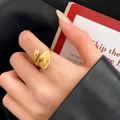 Primer plano de un anillo ajustable de oro minimalista con forma de pétalo pulido - Estilo Dorado de Pétalo Irregular (C-22)