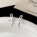 Detail of silver ribbon knot earrings on a white ceramic plate with vintage card - Abstract Knotted Ribbon Style (A-1846)