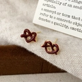 Macro shot of elegant heart-shaped knot stud earrings with dark red enamel and gold trim - Heart-Shaped Knot Style (A-1139)
