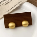 Dettaglio di orecchini a perno semisferici in oro spazzolato su un display in legno - Stile Emisferico (A-618)
