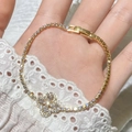 Detail of gold clover charm bracelet with micro-pave zircons and delicate tennis chain - Gold