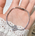Detailed close-up of a silver clover bracelet with micro-pave cubic zirconia on lace - Silver