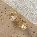 Detail van S925-zilvermerk en glanzende barokparel in een gouden holle zetting - Grote Parelstijl
