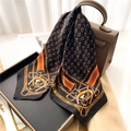 Elegant black chain print square silk scarf draped on a brown leather handbag for styling - Black Equestrian Print Style (FJ655-1)
