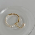 Dettaglio del bracciale fatto a mano con perla barocca e catena a corda dorata - Bracciale di perle