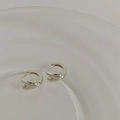 Vista macro di orecchini a goccia d'argento con design moderno a struttura ritorta - Argento