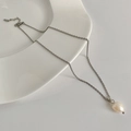 Baroque freshwater pearl pendant on a minimalist gold-plated chain over a ceramic plate - Silver Single Freshwater Pearl Necklace / Silver