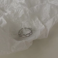 Dettaglio macro di un anello a catena industriale argento su sfondo di carta stropicciata - Ritaglio grande formato / Argento