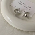 Macro shot of silver twisted hoop earrings with polished finish and S925 hallmark stamp - Silver