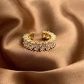 Close-up of adjustable gold ring with oval cubic zirconia on brown satin background - Gold
