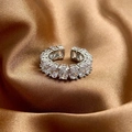 Detailed view of silver adjustable ring with oval-cut cubic zirconia on gold satin fabric - Silver
