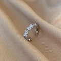 Macro shot of silver butterfly ring with cubic zirconia on champagne silk fabric - Silver