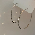 Detalle de aros grandes en tono plateado con efecto martillado y acabado reflectante - 5cm / Plateado