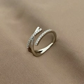Detailed close-up of a silver crossover ring with pavé zircons on textured fabric - Silver