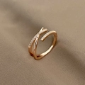 Close-up of rose gold criss-cross ring with pavé zircons on warm textured fabric - Rose Gold