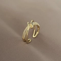 Close-up of gold wrap ring featuring sparkling micro-pave crystals on a textured fabric - Criss-Cross Twisted Micro-Pave Style / Gold