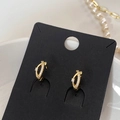 Dettaglio macro di orecchini a lobo incrociati placcati oro con zirconi micro-pave - Stile Incrociato Micro-pavimentato Oro