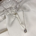 Vue détaillée d'un collier minimaliste argenté avec un zircon brillant serti de six griffes - Argenté