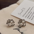 Macro-opname van zilveren bloemoorbellen met parels op vintage getextureerde stof - Geplooide Bloem Parel Oorknopjes / Zilver (Echt Verzilverd)