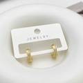 Detailed macro view of gold-plated twisted earrings with white shell inlay on display - Shell Cross Earrings / White