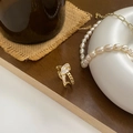 Close-up of gold knotted chain ring with white zircon stones on vintage wooden background - Gold