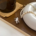 Detailed view of silver knot ring with sparkling zircon stones on a vintage display - Silver
