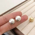 Detail van minimalistische mat parelwitte en gouden druppeloorbellen in een doosje - Mat Zilver (Echt Verzilverd)