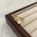 Close-up of golden multi-layer criss-cross ring with white pearl and pave zirconias - Shell Pearl Cross Micro-inlaid Ring / Gold