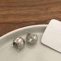 Primer plano de pendientes de bola plateados mate cepillados en plato de cerámica - Pendiente de Bola / Plata Mate Cepillado
