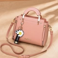 Elegante bolso de cuero rosa palo con colgante de margarita y correa ajustable - Rosa