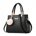 Bolso elegante de cuero sintético negro con logo dorado, pompón y correa de hombro ajustable - Negro