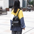 Mini zaino nero in pelle a coccodrillo con ciondolo a orsetto su modella in strada - Nero Piccolo