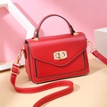 Chic red crossbody bag with contrast stitching and golden hardware on geometric stand - Red