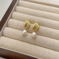 Detail of shell-shaped gold earrings with dangling white freshwater pearls on display - Shell Pearl Stud Earrings (Gold) / Gold