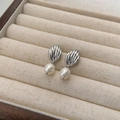 Detailed view of silver shell-shaped earrings with freshwater pearls in a jewelry box - Shell Pearl Stud Earrings (Silver) / Silver