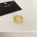 Close-up of a gold leaf ring with white zircon stones on a white and black background - Gold
