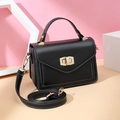 Classic black leather handbag with gold metal lock and contrast stitching on pink background - Black