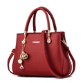 Elegant dark red lychee leather handbag with top handles and floral pendant - Burgundy