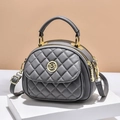 Gray quilted crossbody bag with golden logo and chain strap on minimalist display - Gray