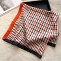 Close-up of houndstooth silk scarf with orange borders on soft white faux fur texture - Red Black Brown Colorblock Houndstooth (FJ547-3)