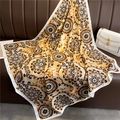 Close-up of golden mandala print silk scarf draped over a brown leather sofa decor - Luxury Golden Yellow Mandala (FN82-2)