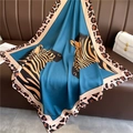 Detail of blue zebra print silk scarf with leopard border on a leather sofa - 90x90cm / Blue Zebra Leopard Patchwork (FN92-1)