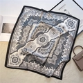 Detail of elegant paisley print silk square scarf styled on a white plush rug backdrop - 70x70cm / Black White Grey Paisley (FJ502-6)