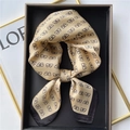 Elegant champagne silk scarf with black bow patterns in a premium gift box setup - Apricot Yellow