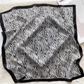 Détail à plat d'un foulard en soie à imprimé zèbre noir et blanc sur un tapis en peluche - 70x70cm / Motif Zèbre Bordure Noire (FJ486-2)