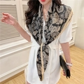 Detail of silk-like scarf featuring golden paisley patterns worn as an elegant shawl - Black Gold Paisley (FE41-1)
