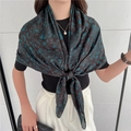 Close-up of a large silk-feel scarf with elegant blue paisley patterns worn by a model - Black Brown Teal Paisley Style (FE56-1)